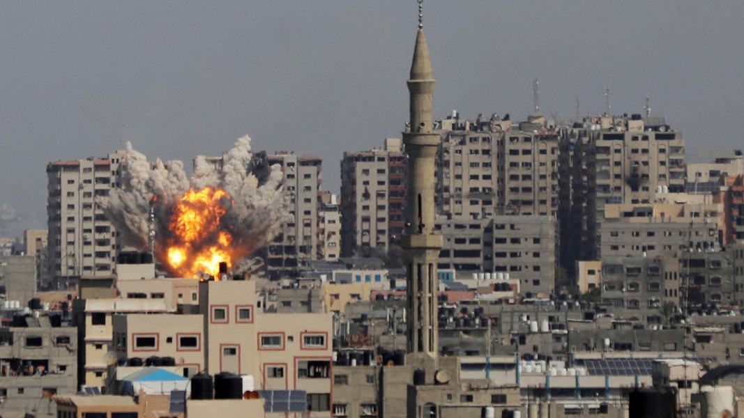 Palästinensische Gebiete, Gaza: Rauchschwaden und Flammen einer Explosion sind während eines israelischen Luftangriffs zu sehen. 