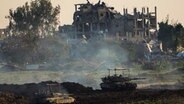 Israelische Panzer stehen vor einem zerstörten Gebäude während einer Bodenoperation im nördlichen Gazastreifen. © dpa-Bildfunk/AP Foto: Ariel Schalit