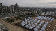 Ein Zeltlager für vertriebene Palästinenser wird inmitten zerstörter Gebäude im Westen des Lagers Al-Schati, westlich von Gaza-Stadt, errichtet. © Jehad Alshrafi/AP/dpa 