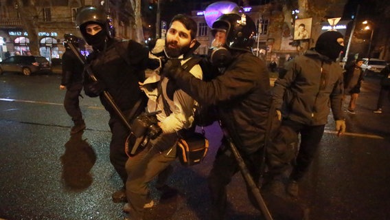 Polizisten halten den Journalisten Giorgi Chamelishvili während einer Kundgebung vor dem Parlamentsgebäude in Tiflis fest. © Zurab Tsertsvadze/AP/dpa 