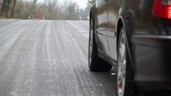 Ein Auto steht auf einer glatten Straße. © picture alliance/dpa | Harald Tittel 