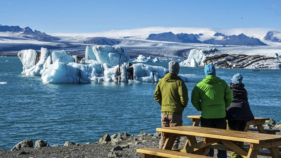 Touristen beobachten die Gletscherlagune Jökulsarlon am Vatnajökull, dem größten Gletscher auf Island. © picture alliance / imageBROKER | Andreas Werth 