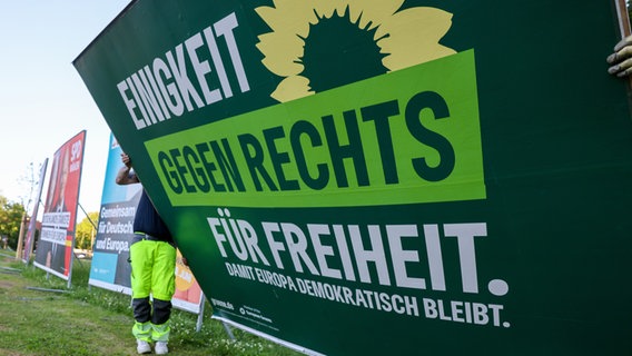 Zwei Männer bauen ein Wahlplakat der Grünen nach der Europawahl ab. © picture alliance/dpa Foto: Jan Woitas