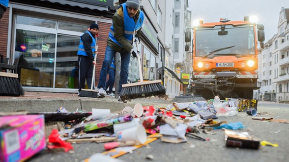 Mitarbeiter der Stadtreinigung aha und Mitglieder vom Verein Majlis Khuddam-ul-Ahmadiyya Deutschland befreien den Lister Platz in Hannover vom Abfall aus der Silvesternacht. © Julian Stratenschulte/dpa 