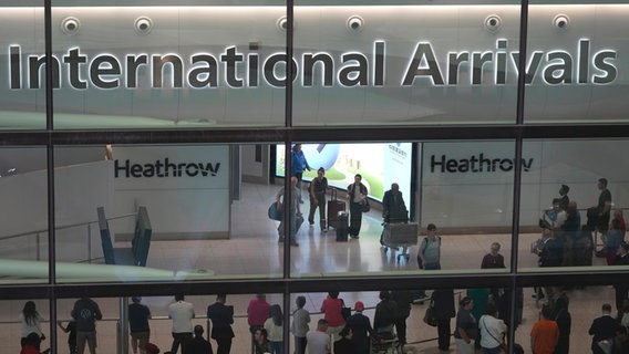 Passagiere kommen am International Arrivals auf dem Flughafen Heathrow in London an. © Kin Cheung/AP/dpa 