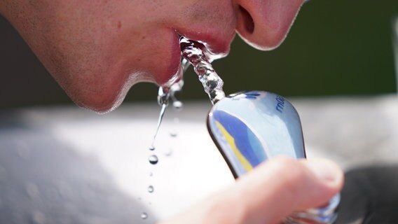 Ein Mensch trinkt Wasser an einem öffentlichen Wasserspender an der Außenalster in Hamburg. © dpa-Bildfunk Foto: Marcus Brandt