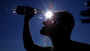 Ein Mann erfrischt sich mit Wasser aus einer Flasche. © picture-alliance/ dpa | Karl-Josef Hildenbrand Foto: Karl-Josef Hildenbrand