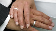 Bräutigam und Braut halten sich die Hände. © dpa - Bildfunk Foto: Jens Wolf