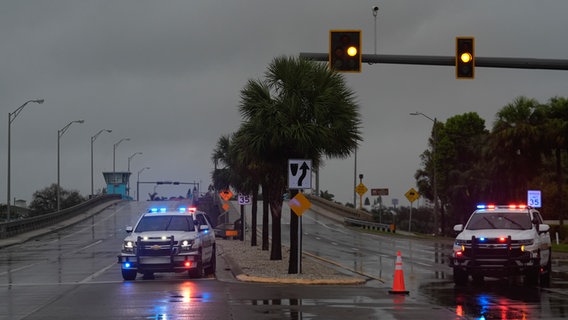 Die Polizei sperrt eine Brücke ab, die zur Insel St. Pete Beach (Florida) führt, bevor der Hurrikan Milton eintrifft. © picture alliance/dpa/AP Foto: Rebecca Blackwell