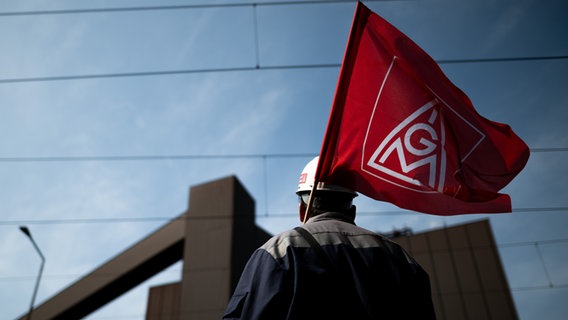 Ein Mann mit einem Helm trägt eine IG Metall-Fahne © picture alliance/dpa | Fabian Strauch Foto: Fabian Strauch