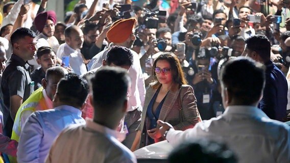Rani Mukherjee (M.), Bollywood-Schauspielerin, kommt an einem Flughafen in Indien an und wird von Journalisten und Schaulustigen umringt. © dpa-Bildfunk/AP Foto: Ajit Solanki