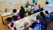 Teilnehmerinnen und Teilnehmer lernen in einem Integrationskurs mit Alphabetisierung im Eltern-Kind-Zentrum (EKiZ) in der Elbkinder-Kita Uffelnsweg. © picture alliance/dpa | Christian Charisius Foto: Christian Charisius