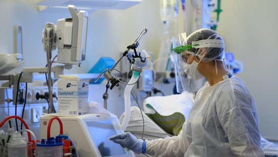 An intensive care nurse in protective clothing is busy caring for corona patients in a Covid-19 intensive care unit.  © dpa-Zentralbild / dpa Photo: Robert Michael