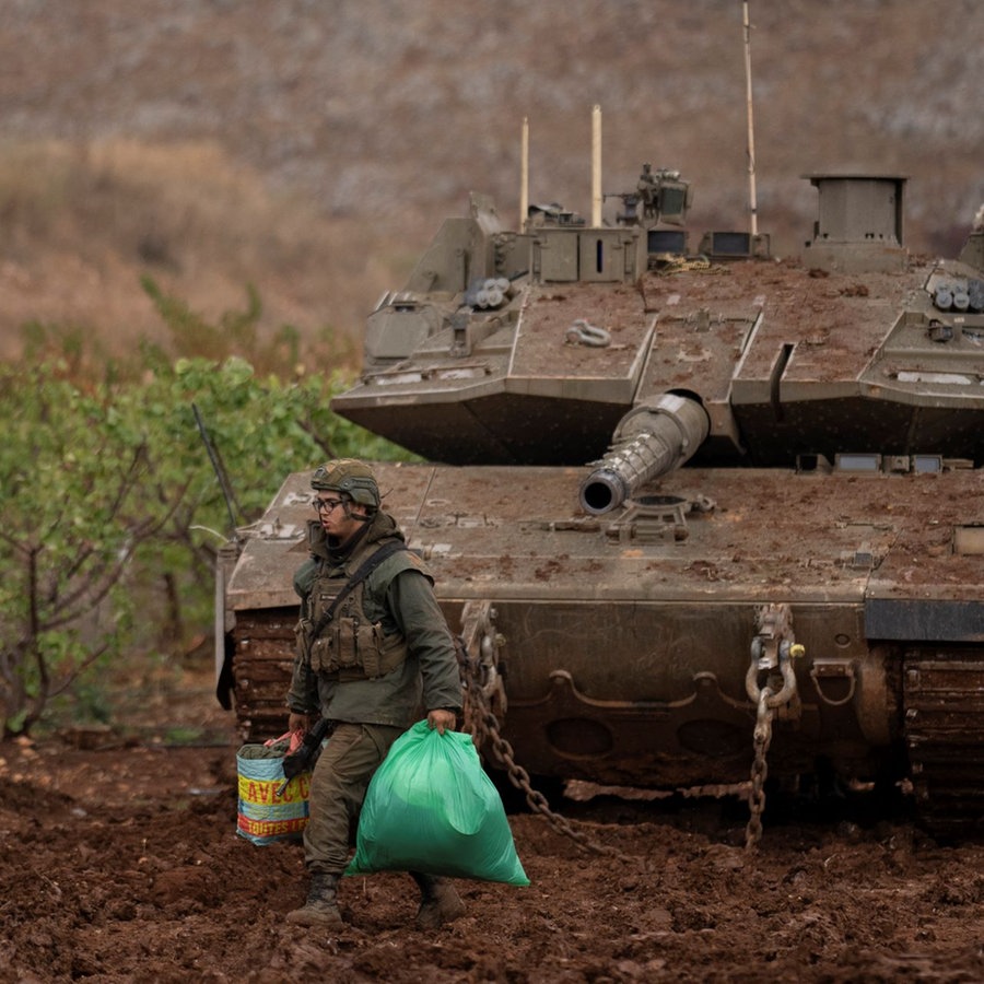 Ein israelischer Soldat geht an einem Panzer in der Nähe der israelisch-libanesischen Grenze vorbei, gesehen von Nordisrael aus. © picture alliance/dpa/AP | Leo Correa Foto: Leo Correa