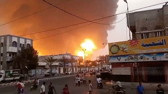 Rauch und Flammen steigen hinter Gebäuden im Jemen auf. © picture alliance/dpa/AP Foto: Uncredited