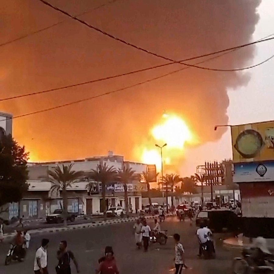 Rauch und Flammen steigen hinter Gebäuden im Jemen auf. © AP Foto: Uncredited