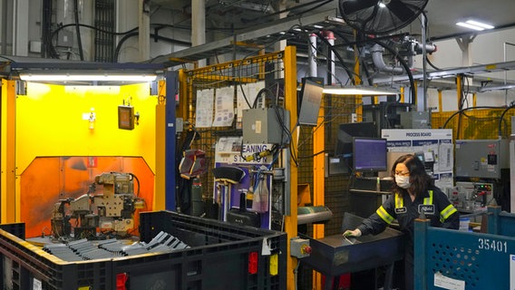 Eine Angestellte arbeitet in Woodbridge, Ontario, Kanada am Fließband in der Martinrea Fabrik, die Autoteile sowohl an kanadische als auch an US-amerikanische Autofabriken liefert. © Chris Young/The Canadian Press/AP/dpa 