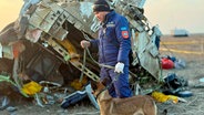 Auf diesem, vom Pressedienst des kasachischen Katastrophenschutzministeriums zur Verfügung gestellten Foto arbeiten Rettungskräfte am Wrack der Embraer 190 der Azerbaijan Airlines in der Nähe des Flughafens von Aktau. Ein Passagierflugzeug aus Aserbaidschan ist am 25.12.2024 nahe der Stadt Aktau in Kasachstan abgestürzt. © Kazakhstan's Emergency Ministry/AP/dpa 