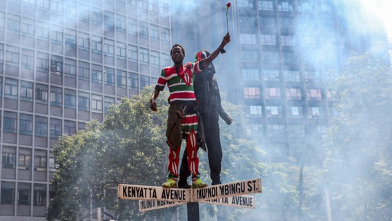 Ein Demonstrant auf einem Straßenschild in der kenianischen Hauptstadt Nairobi © SOPA Images/dpa Foto: Boniface Muthoni