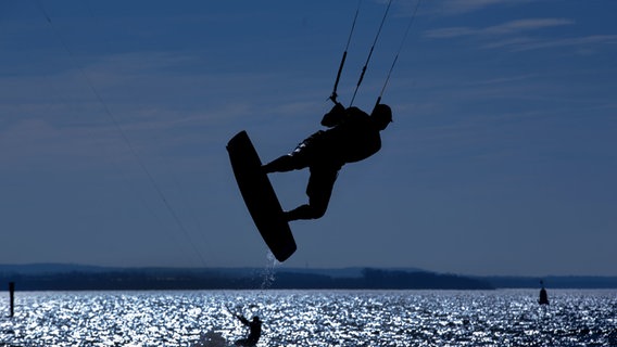 Ein Kitesurfer ist auf der Ostsee bei Timmendorf unterwegs (Symbolbild). © Jens Büttner/dpa 