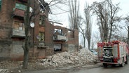 Ein Feuerwehrfahrzeug steht vor einem durch russischen Beschuss teilweise zerstörten Wohnhaus in Kramatorsk in der Region Donezk. © -/ukrin/dpa 