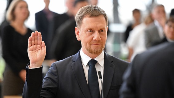 Michael Kretschmer (CDU) legt nach der Wahl zum Ministerpräsidenten von Sachsen im Plenarsaal im Sächsischen Landtag den Amtseid ab. © dpa-Bildfunk Foto: Robert Michael