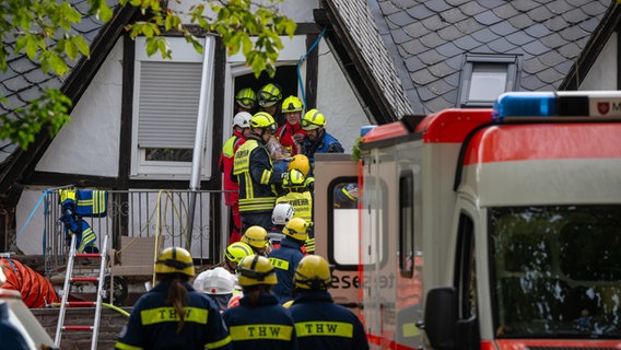 Ein Mensch wird von Rettungskräften aus dem teilweise eingestürzten Hotel in Kröv gerettet. © Harald Tittel/dpa 