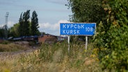 Ein Schild mit der Aufschrift "Kursk 108 km" steht an der russisch-ukrainischen Grenze. © Evgeniy Maloletka/AP/dpa 