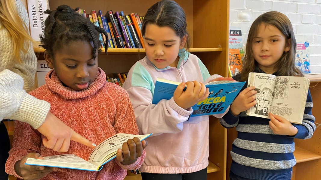 Kinder der Klassen 2c und 2d der Grundschule Kirchdorf in Hamburg lesen in Büchern, mit denen sie das sogenannte Leseband erlernen.