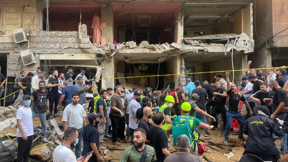 Menschen versammeln sich am Ort eines israelischen Raketeneinschlags in den südlichen Vororten von Beirut. © Bilal Hussein/AP 