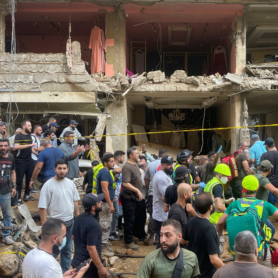 Menschen versammeln sich am Ort eines israelischen Raketeneinschlags in den südlichen Vororten von Beirut. © Bilal Hussein/AP 