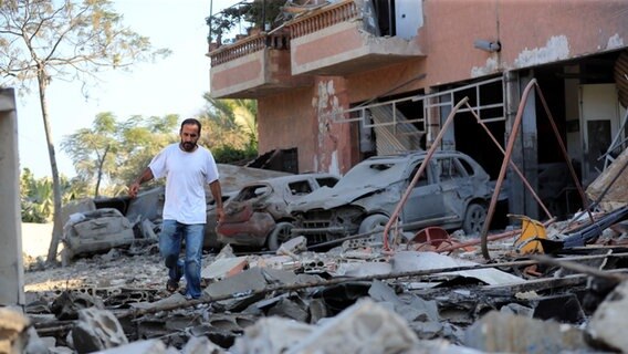 Ein Mann prüft die Schäden an einem Gebäude, das bei einem israelischen Luftangriff im Dorf Akbieh im Süden Libanons getroffen wurde. © picture alliance/dpa/AP | Foto: Mohammed Zaatari