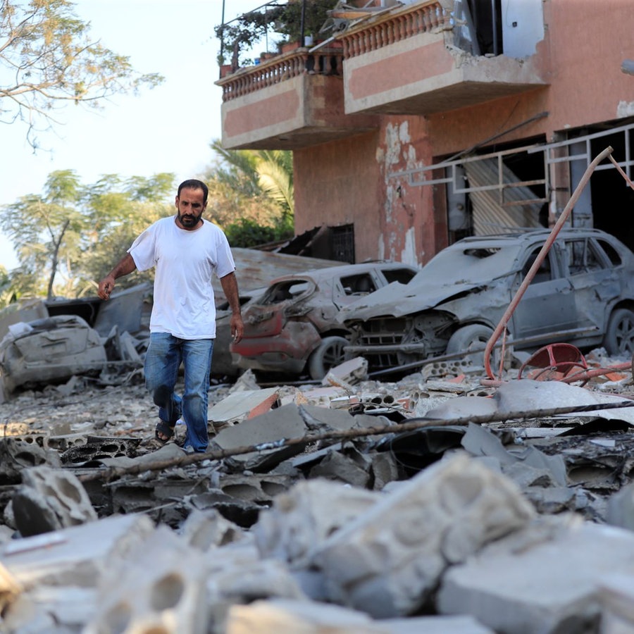 Ein Mann prüft die Schäden an einem Gebäude, das bei einem israelischen Luftangriff im Dorf Akbieh im Süden Libanons getroffen wurde. © picture alliance/dpa/AP | Foto: Mohammed Zaatari