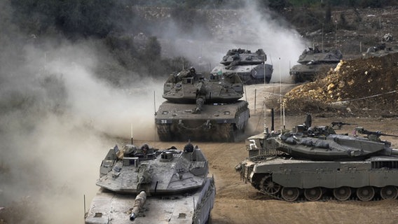 Panzer der israelischen Armee manövrieren in einem Bereitstellungsraum im Norden Israels nahe der israelisch-libanesischen Grenze. © Baz Ratner/AP/dpa Foto: Baz Ratner