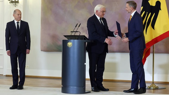 Bundespräsident Frank-Walter Steinmeier (M.) übergibt Christian Lindner (r./FDP) Entlassungsurkunde als Finanzminister. Bundeskanzler Olaf Scholz (SPD) schaut zu. © dpa bildfunk Foto: Christoph Soeder