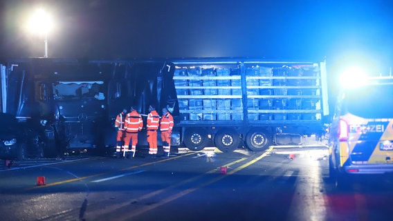 Einsatzkräfte stehen neben einem Lastwagen auf der Autobahn 1 bei Hagen © Sascha Thelen/dpa Foto: Sascha Thelen/dpa