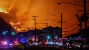 Stau auf einer Straße in Los Angeles, im Hintergrund tobt ein Waldbrand © Amy Katz/ZUMA Press Wire/dpa Foto: Amy Katz