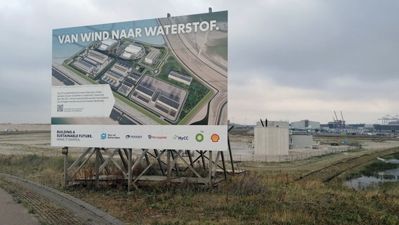 Eine große Tafel im Rotterdamer Hafen weist auf eine Baustelle für grünen Wasserstoff hin. © NDR Info Foto: Marc-Olver Rehrmann