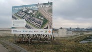 Eine große Tafel weist im Rotterdamer Hafen auf eine Baustelle für grünen Wasserstoff hin. © NDR Info Foto: Marc-Olver Rehrmann