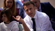 Emmanuel Macron, Präsident von Frankreich, gestikuliert während eines Gesprächs mit Schülern. © Daniel Cole/Pool AP/AP 