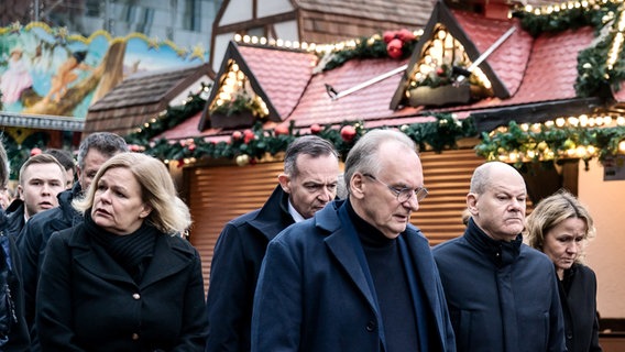 Bundesinnenministerin Nanca Faeser (SPD) mit Kanzler Olaf Scholz (SPD), Sachsen-Anhalts-Ministerpräsident Reiner Haseloff (CDU) und anderen Politikern auf dem Magdeburger Weihnachtsmarkt © Jesco Denzel/Bundespresseamt/dpa Foto: Jesco Denzel