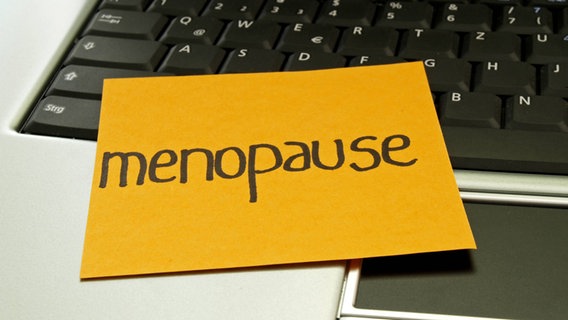 Ein Notizzettel mit der Aufschrift "Menopause" liegt auf einem Laptop © xKTHx ALLF931679 