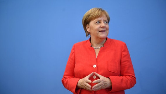 Angela Merkel bei ihrer Sommerpresse-Konferenz, die trägt ein Rotes Jacket. © dpa-Bildfunk Foto: Bernd Von Jutrczenka