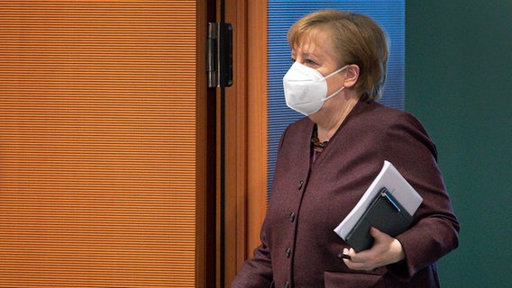 Angela Merkel betritt mit einer FFP2-Maske einen Sitzungsraum. © dpa-Bildfunk/POOL AP Foto: Michael Sohn