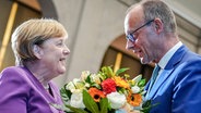 Friedrich Merz überreicht Angela Merkel zum 70. Geburtstag einen Blumenstrauß. © dpa-Bildfunk Foto: Kay Nietfeld