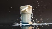 Ein Glas mit Milch, die über den Rand hinausläuft und einige Euro Geldstücke liegen auf dem Boden © picture alliance / dpa Foto: Paul Zinken