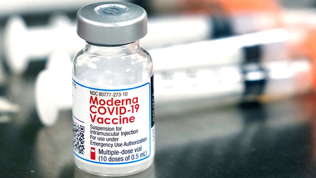 Ein Fläschchen des Moderna-Impfstoffes gegen das Coronavirus steht neben Spritzen.