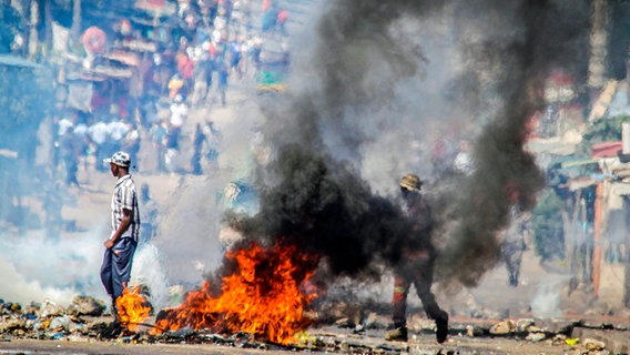 Eine Barrikade brennt in Mosambiks Hauptstadt Maputo. Die Proteste haben das Land erfasst, nachdem die Opposition die Ergebnisse der Wahlen abgelehnt hat, die eine Verlängerung der 58-jährigen Herrschaft der Frelimo-Partei zur Folge hatten. © Carlos Uqueio/AP/dpa 