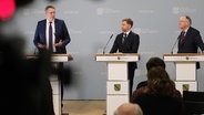 Auf dem Bild sind Alexander Schweitzer (SPD), Ministerpräsident des Landes Rheinland-Pfalz, Michael Kretschmer (CDU), Ministerpräsident des Landes Sachsen, und Stephan Weil (SPD) Ministerpräsident des Landes Niedersachsen, zu sehen - sie sprechen auf einer Pressekonferenz. Dort wurden die Ergebnisse der Ministerpräsidentenkonferenz erläutert. © Sebastian Willnow/dpa Foto: Sebastian Willnow/dpa