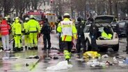 Rettungskräfte stehen am Einsatzort, nachdem ein Auto in der Münchner Innenstadt in eine Menschenmenge gefahren ist. © dpa Foto: Peter Kneffel